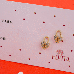 Con estos aretes (topos) vos llevás un candado en forma de corazón forrado de cristales pavé y montado en oro laminado hipoalergénico. Son ligeros, resistentes y aportan un aire de protección y sofisticación a tu estilo diario o en ocasiones especiales. Descubrí vos cómo elevás tu look con este diseño simbólico.