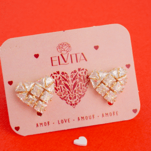 Con estos aretes (topos) vos llevás un corazón formado por cristales tipo princess cut sobre base de oro laminado. Son ligeros, hipoalergénicos y súper resistentes, ideales pa’ añadir un toque geométrico y sofisticado a tu look diario o en eventos especiales. Descubrí vos cómo este diseño brilla con pura elegancia.