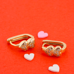Con estos aretes huggies en oro laminado vos lucís dos corazones pequeños forrados de cristales pavé que captan cada rayo de luz. Son hipoalergénicos, ligeros y resistentes, perfectos pa’ darle un toque romántico y brillante a tu estilo diario o en ocasiones especiales. Descubrí vos cómo este diseño doble eleva tu look con pura elegancia.